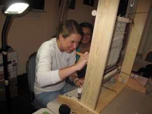 Learn to weave!++Laramie Blake right helps a student with her first weaving.