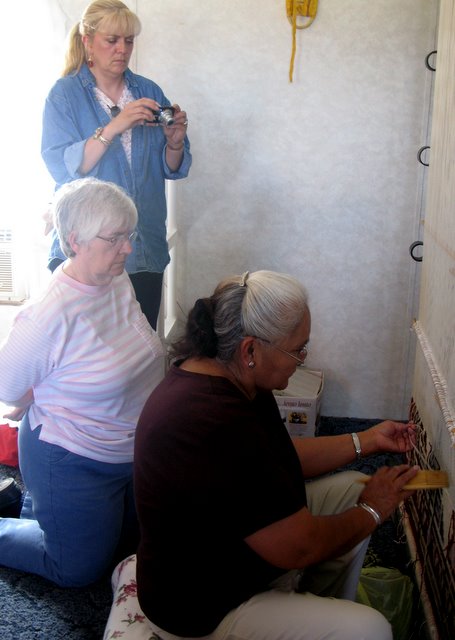 Jennie Slick, right, demonstrates weaving to Tammy Denhard (standing) and Arlene Anderson