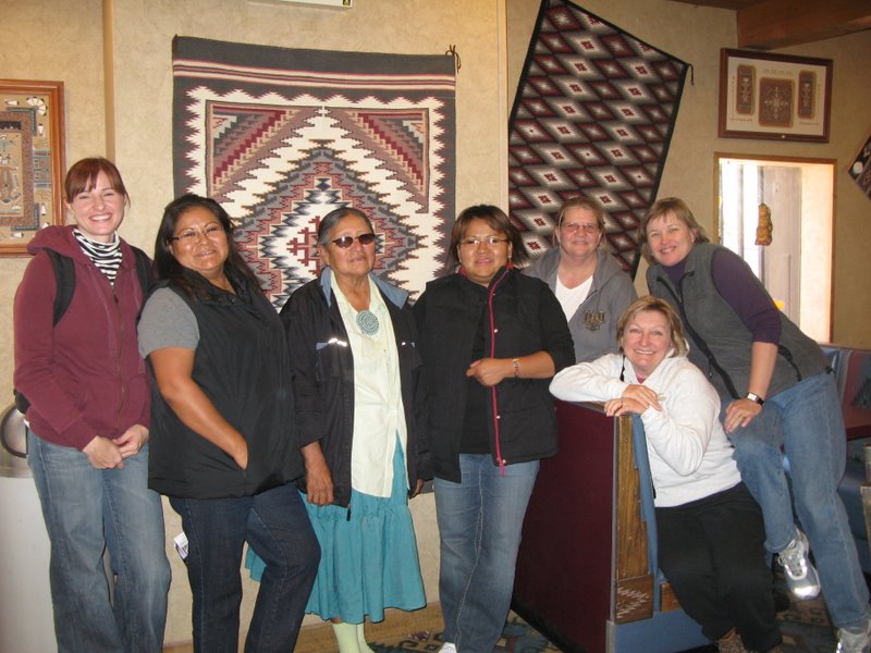 From left, Lisa Ward, Emily Malone, Rose Yazzie, Lavera Blake, Debi Ward, Cindy Henry and Diana Frawley in front of one of Lavera's Burntwater rugs at the Thunderbird Lodge. 