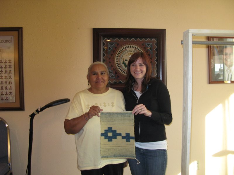 Jennie Slick and Lisa Ward show off Lisa's finished weaving.  Lisa is a newcomer to Navajo weaving techniques. 