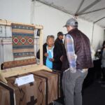 Gloria Begay talks with a fair visitor. Shall we take a closer look at the weaving?